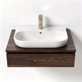 Wall-mounted bathroom sink with dark wood vanity and white ceramic basin